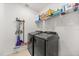 Efficient laundry room with modern washer and dryer, ample shelving for supplies, and tiled floor at 849 Avenal Ln, Davenport, FL 33837