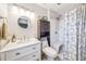 Updated bathroom features a white vanity, a round mirror, and a shower with seat at 8619 Veridian Dr, Orlando, FL 32810