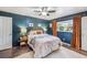 Cozy bedroom features dark blue walls, a ceiling fan, and natural light from the window at 8619 Veridian Dr, Orlando, FL 32810