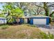 Charming home featuring a blue painted exterior, complemented by lush greenery and a white garage door at 8619 Veridian Dr, Orlando, FL 32810