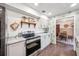 Galley kitchen with stainless appliances, granite counters, open shelf and view into the dining room at 8619 Veridian Dr, Orlando, FL 32810
