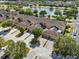 An aerial view showcases this neighborhood's charming townhomes and lush landscaping, near a peaceful lake at 9009 Savannah Julip Ln, Orlando, FL 32832