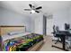 A well-lit bedroom with a ceiling fan and adjacent desk area at 9009 Savannah Julip Ln, Orlando, FL 32832