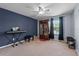 Relax in this bedroom with a navy accent wall, ceiling fan, and a sunny window at 9009 Savannah Julip Ln, Orlando, FL 32832