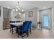 Stylish dining area featuring a marble table, blue chairs, elegant lighting and decor at 9009 Savannah Julip Ln, Orlando, FL 32832