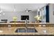 A stylish kitchen island features granite countertops, modern fixtures, and a view into the living area at 9009 Savannah Julip Ln, Orlando, FL 32832