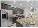 Modern kitchen with stainless steel appliances, granite countertops, and dark wood cabinets at 9009 Savannah Julip Ln, Orlando, FL 32832