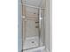 Walk-in shower with neutral tile, glass door, and integrated shower head at 9009 Savannah Julip Ln, Orlando, FL 32832