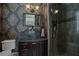 Stylish bathroom with dark vanity, glass bowl sink, and walk-in shower with decorative tile accents at 9730 Lounsberry Cir, Golden Oak, FL 32836