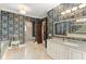 A luxurious bathroom offers elegant wallpaper, granite counters, and a step-in shower space at 9730 Lounsberry Cir, Golden Oak, FL 32836
