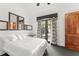 Bright bedroom with white bedding, dark carpet, and an outdoor view of the backyard at 9730 Lounsberry Cir, Golden Oak, FL 32836