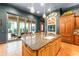 Kitchen featuring granite countertops, center island, brick fireplace, and backyard pool access at 9730 Lounsberry Cir, Golden Oak, FL 32836
