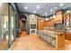 Gourmet kitchen with dark wood cabinets, tile floors, a large island with seating, and access to a library at 9730 Lounsberry Cir, Golden Oak, FL 32836