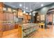 Spacious kitchen with dark walls, wood cabinets, large island with seating, and custom range hood at 9730 Lounsberry Cir, Golden Oak, FL 32836
