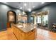 An open-concept kitchen boasts a spacious island, stainless appliances, and an adjacent outdoor living area at 9730 Lounsberry Cir, Golden Oak, FL 32836