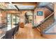Stylish living and dining area with exposed beams, unique wall texture, and staircase access at 9730 Lounsberry Cir, Golden Oak, FL 32836