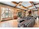 Spacious living room with exposed wood beams, tile flooring, and a large comfortable sectional at 9730 Lounsberry Cir, Golden Oak, FL 32836