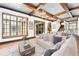 Bright living room features a cozy seating arrangement, wooden ceiling beams and natural light at 9730 Lounsberry Cir, Golden Oak, FL 32836