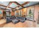 Beautifully designed living space with exposed beams, tile flooring, and comfortable seating arrangements at 9730 Lounsberry Cir, Golden Oak, FL 32836