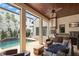 Covered outdoor kitchen and dining area with a pool view, ideal for entertaining guests at 9730 Lounsberry Cir, Golden Oak, FL 32836