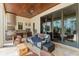 Covered patio with stone floors features a full outdoor kitchen and comfortable seating area at 9730 Lounsberry Cir, Golden Oak, FL 32836