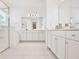 Bright bathroom with large mirrors, white cabinets, shower and tub at 10139 Austrina Oak Loop, Winter Garden, FL 34787
