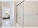 Bright bathroom featuring a glass shower door and tile flooring with a view into the bedroom at 10139 Austrina Oak Loop, Winter Garden, FL 34787