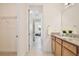 Well-lit bathroom with granite vanity top, tiled floor, and access to the bedroom and closet at 10139 Austrina Oak Loop, Winter Garden, FL 34787