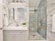 Modern bathroom with a glass shower, patterned tile, and white cabinets at 10139 Austrina Oak Loop, Winter Garden, FL 34787