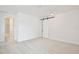 A spacious bedroom featuring a sliding barn door and access to a bathroom with modern design at 10139 Austrina Oak Loop, Winter Garden, FL 34787