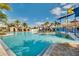 Community pool featuring shallow water area, waterslide, lounge areas, and tropical landscaping at 10139 Austrina Oak Loop, Winter Garden, FL 34787