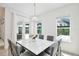 Bright dining room with view to outdoor living, white table, gray upholstered chairs and bench seating at 10139 Austrina Oak Loop, Winter Garden, FL 34787