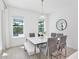 Contemporary dining room featuring a white table, gray chairs, and a view of the pool at 10139 Austrina Oak Loop, Winter Garden, FL 34787
