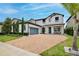 Attractive two-story home featuring a brick driveway, manicured landscaping, two-car garage, and covered porch at 10139 Austrina Oak Loop, Winter Garden, FL 34787