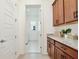 Convenient laundry room with modern cabinets, granite counters, and a bright, functional layout at 10139 Austrina Oak Loop, Winter Garden, FL 34787