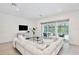 Stylish living room with white sofa, view of patio, pool and nature at 10139 Austrina Oak Loop, Winter Garden, FL 34787