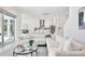 Bright, open-concept living space with white sofa, glass table and view of the modern kitchen and backyard at 10139 Austrina Oak Loop, Winter Garden, FL 34787