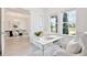 Stylish home office featuring a modern glass desk and comfortable chair, adjacent to an elegant dining room at 10139 Austrina Oak Loop, Winter Garden, FL 34787