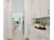 Walk-in pantry with white cabinetry and countertops and stainless-steel refrigerator at 10139 Austrina Oak Loop, Winter Garden, FL 34787
