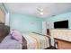 This bedroom boasts ample space, a ceiling fan, and a dresser for storage, all enhanced by wood flooring at 1037 Abagail Dr, Deltona, FL 32725