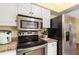 Modern kitchen with stainless steel appliances, a built-in microwave, and ample counter space at 1037 Abagail Dr, Deltona, FL 32725