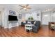 Bright living room with wood-look flooring, a ceiling fan, and cozy seating arrangement with throw pillows at 1037 Abagail Dr, Deltona, FL 32725