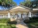 Attractive community clubhouse featuring lush landscaping, a welcoming entrance, and white pillar supports at 112 Crown Oaks Way # 112, Longwood, FL 32779