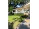 Clubhouse exterior featuring a manicured green lawn, stone accents, covered porch, and white columns at 112 Crown Oaks Way # 112, Longwood, FL 32779