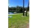 Relaxing community lake featuring a floating dock, lush greenery, and mature trees under a sunny blue sky at 112 Crown Oaks Way # 112, Longwood, FL 32779