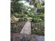 Beautiful garden featuring a stone waterfall, winding brick walkway, lush plants and manicured flowerbeds at 112 Crown Oaks Way # 112, Longwood, FL 32779