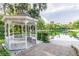 Charming gazebo with seating, set beside a tranquil pond and lush tropical vegetation at 112 Crown Oaks Way # 112, Longwood, FL 32779