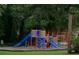 Community playground with brightly colored equipment, slides, climbing structures, and mature shade trees at 112 Crown Oaks Way # 112, Longwood, FL 32779