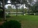 Picturesque pond surrounded by lush green grass and mature trees, creating a tranquil community space at 112 Crown Oaks Way # 112, Longwood, FL 32779