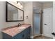 Bathroom featuring a granite countertop, framed mirror, and a glass-enclosed shower at 1130 Hardy Ave, Orlando, FL 32803